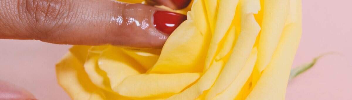 dedos brincando com uma flor representando o dia da masturbação