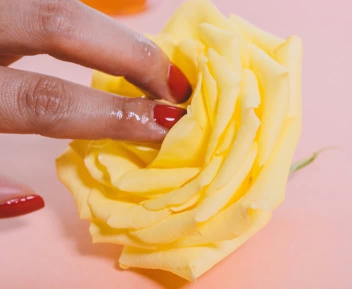 dedos brincando com uma flor representando o dia da masturbação