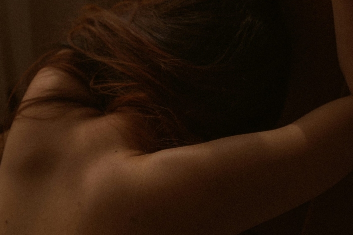 vista de costas de uma mulher apoiada na parede tendo um orgasmo feminino