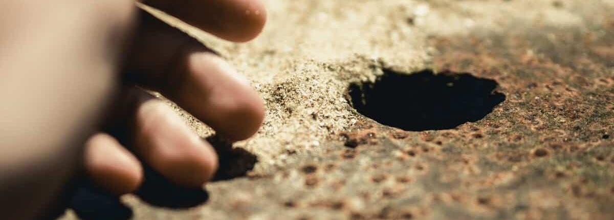 mão perto de um buraco para um fio terra