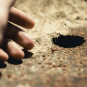 mão perto de um buraco para um fio terra