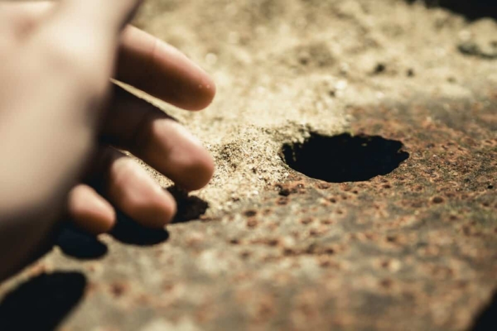 mão perto de um buraco para um fio terra