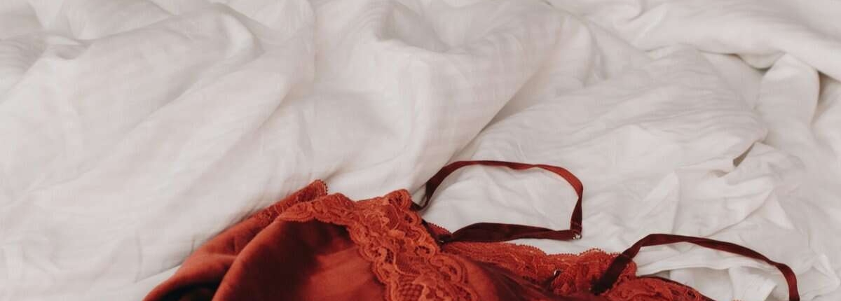 Lingerie vermelha roupa vermelha em cima da cama, simbolismo para o sexo menstruada