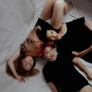 Três mulheres na cama querendo fazer sexo a três